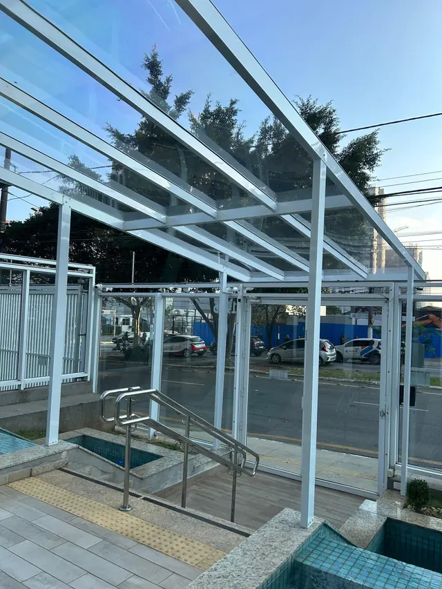 Cobertura fixa em policarbonato transparente sobre área de piscina
