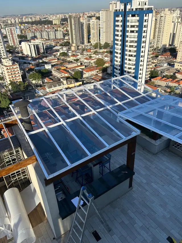Cobertura retrátil em policarbonato sobre terraço com vista panorâmica de São Paulo